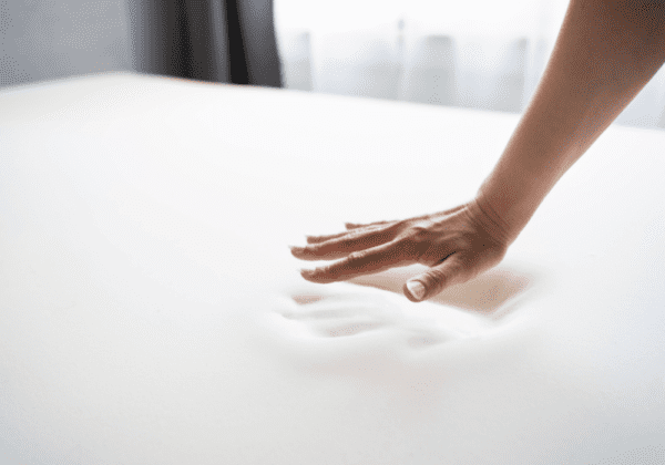 A person testing out the memory foam with their hand